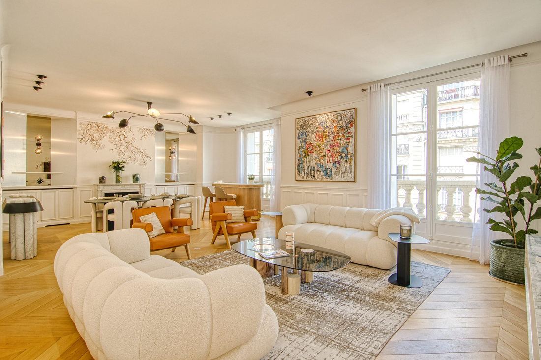 Séjour de l’appartement Émile : canapés bouclés, parquet à chevrons et grande toile contemporaine