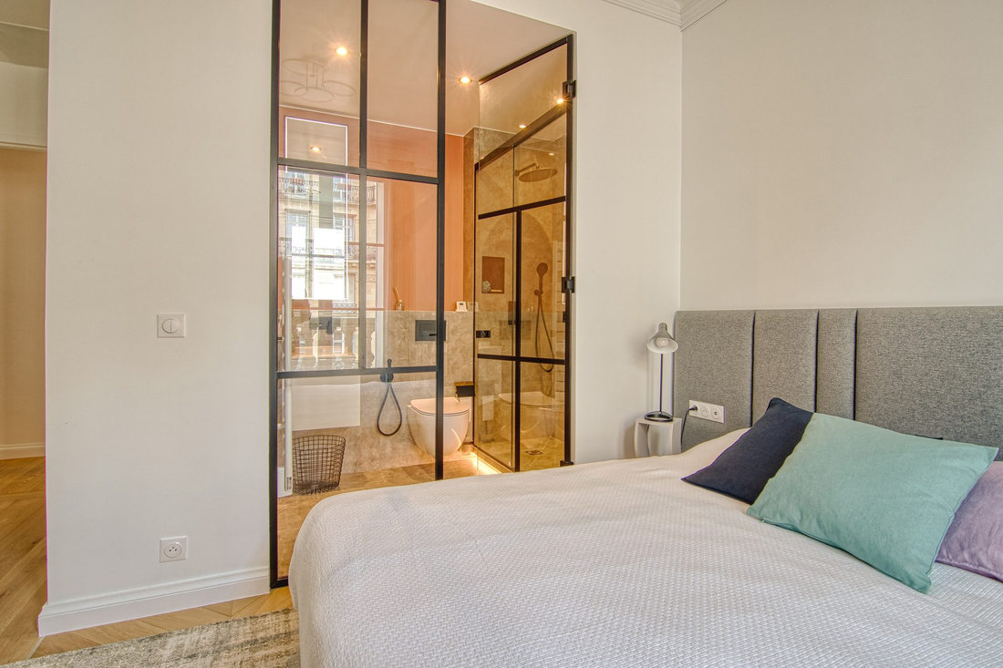 Chambre et salle de bains attenante, visible derrière la verrière