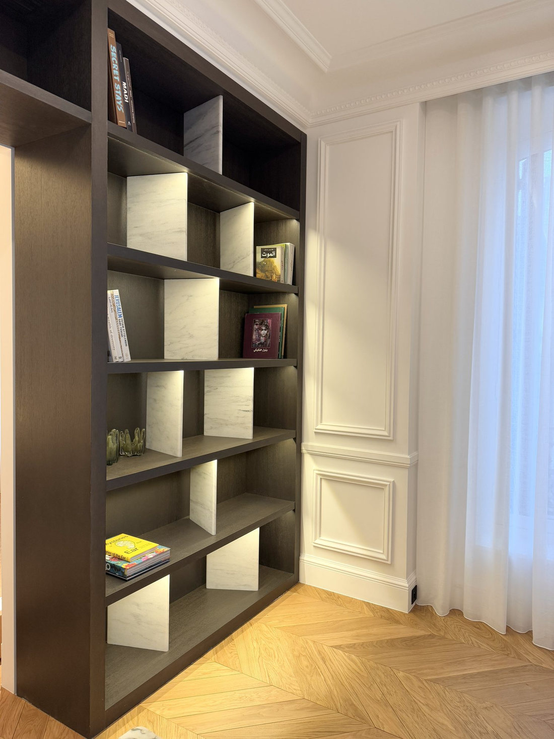 Niches éclairées de la bibliothèque sur mesure du duplex Maubourg
