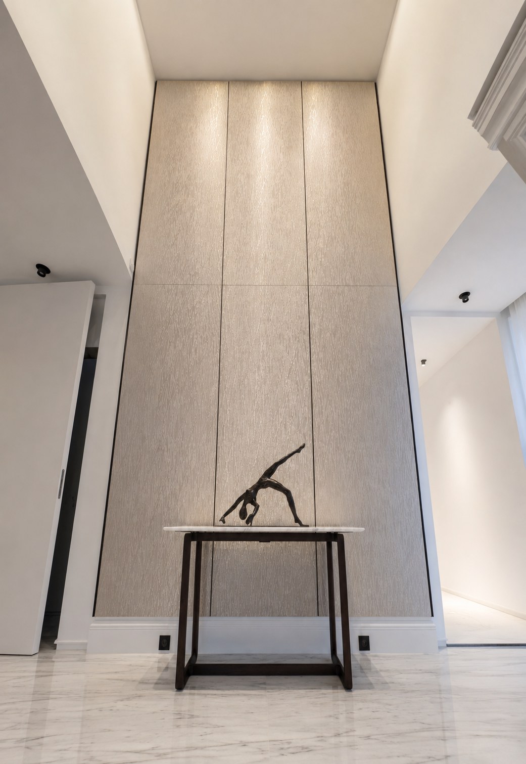 Entrée du duplex Maubourg avec panneau décoratif toute hauteur et console en marbre