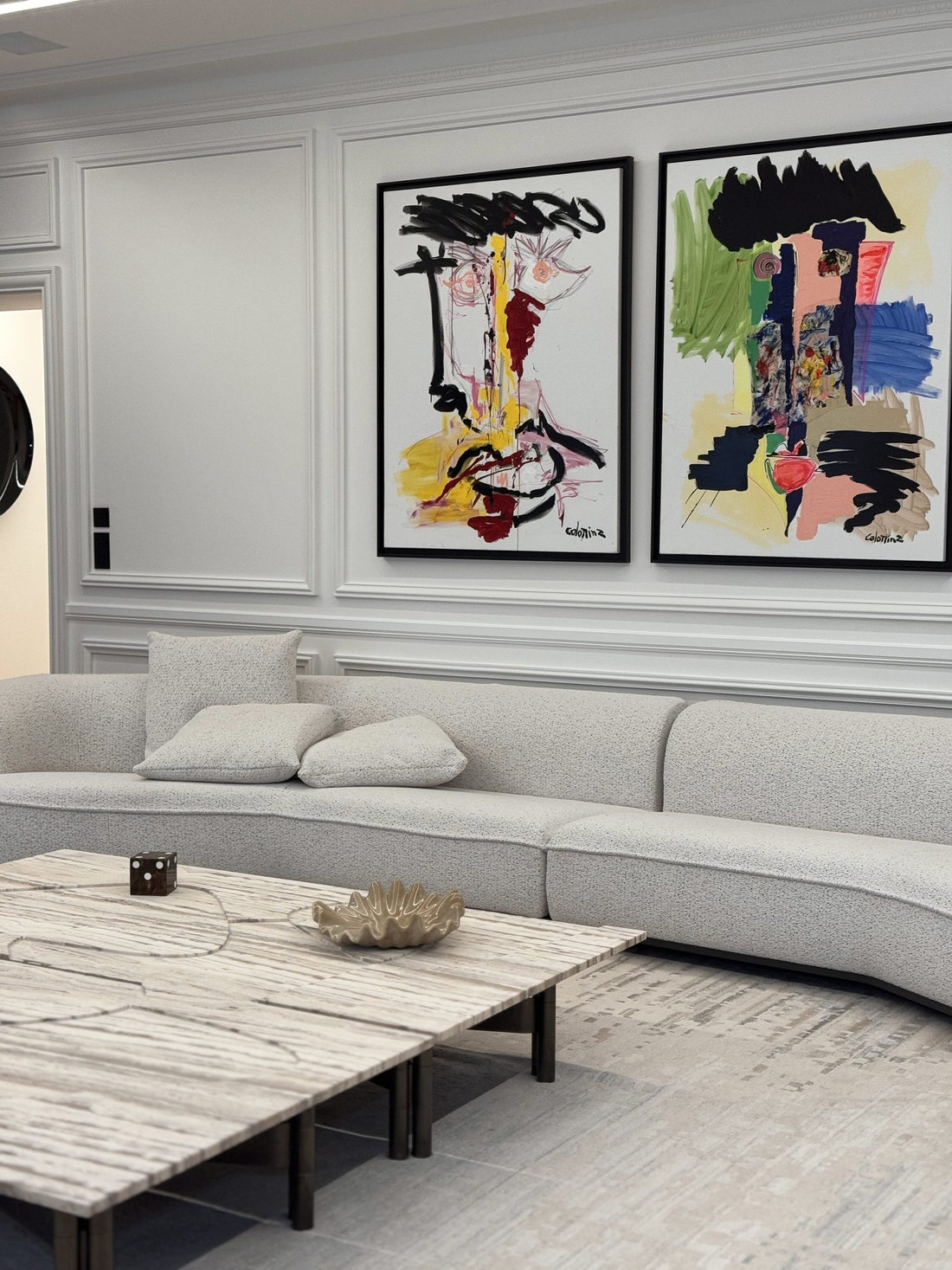 Séjour du duplex Maubourg : canapé courbe et grands formats encadrés sur boiseries