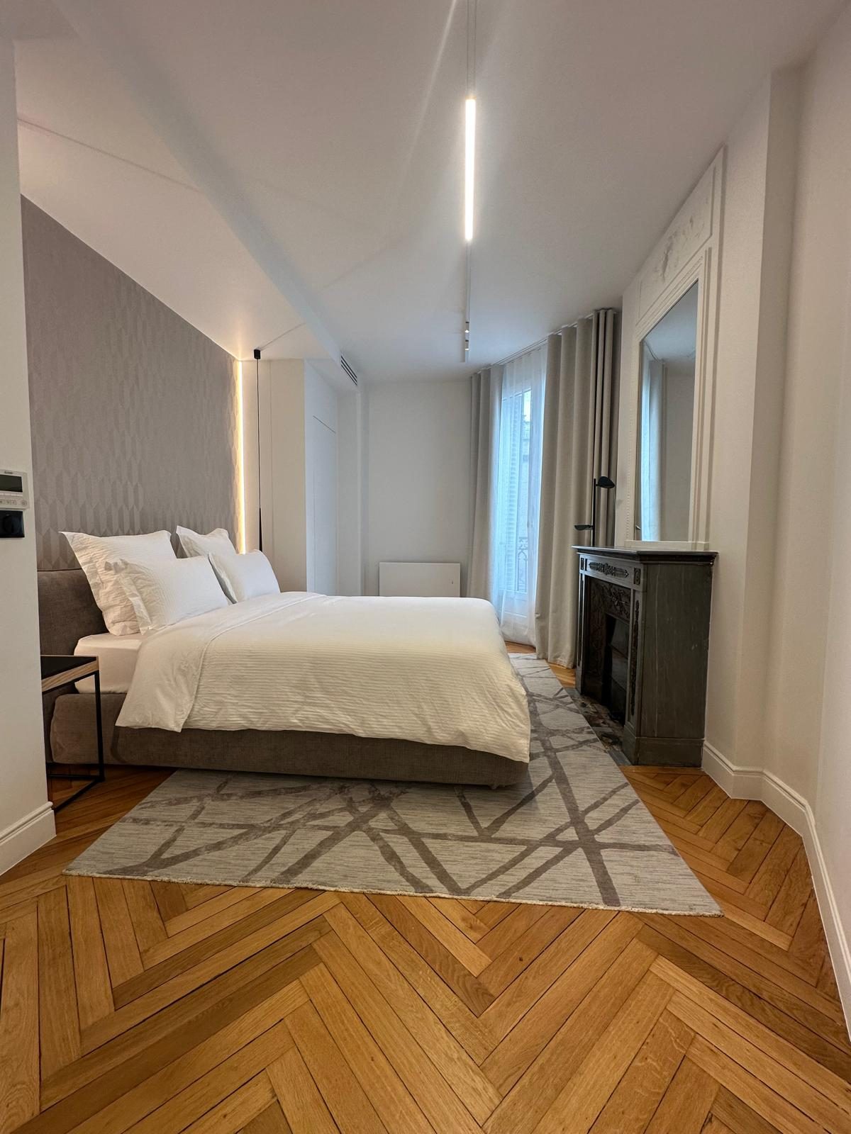 Seconde chambre du duplex Périer, tête de lit habillée et cheminée en marbre