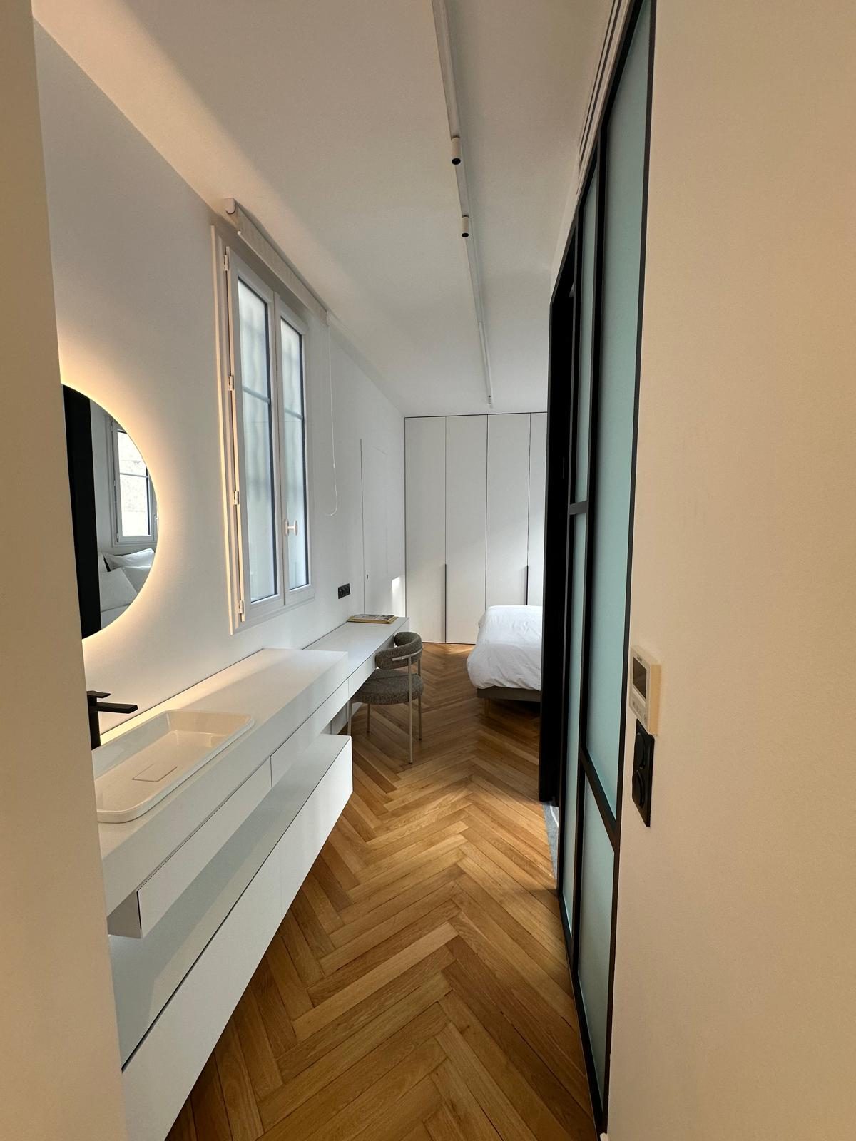 Même chambre du duplex Périer vue depuis le plan vasque et son miroir rond